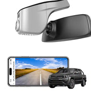 Car rearview mirror with built-in camera and smartphone displaying road view, with a black SUV in the background.