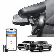 Car side mirror with camera and smartphone displaying app interface, with two trucks in the background.
